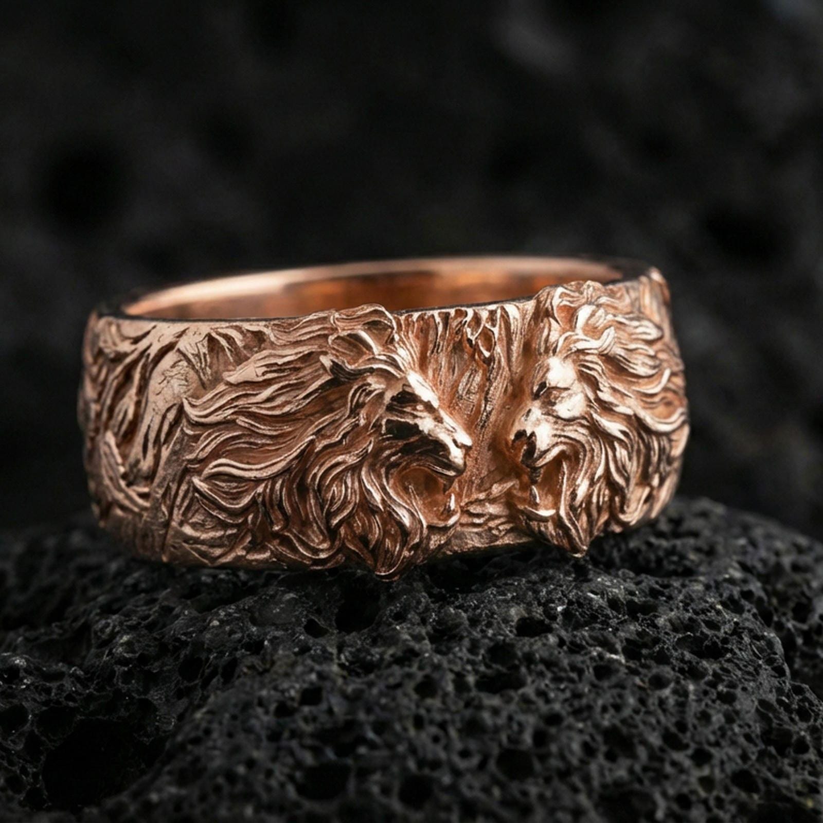 Rose gold plated lion head ring on volcanic stone, refined macro close-up showcasing soft rose sheen, dimensional lion heads, and detailed mane carving.
