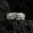 Load image into Gallery viewer, Polished silver skull ring on volcanic stone, sharp macro photo emphasizing clean shine, crisp skull contours, and high-relief detailing.
