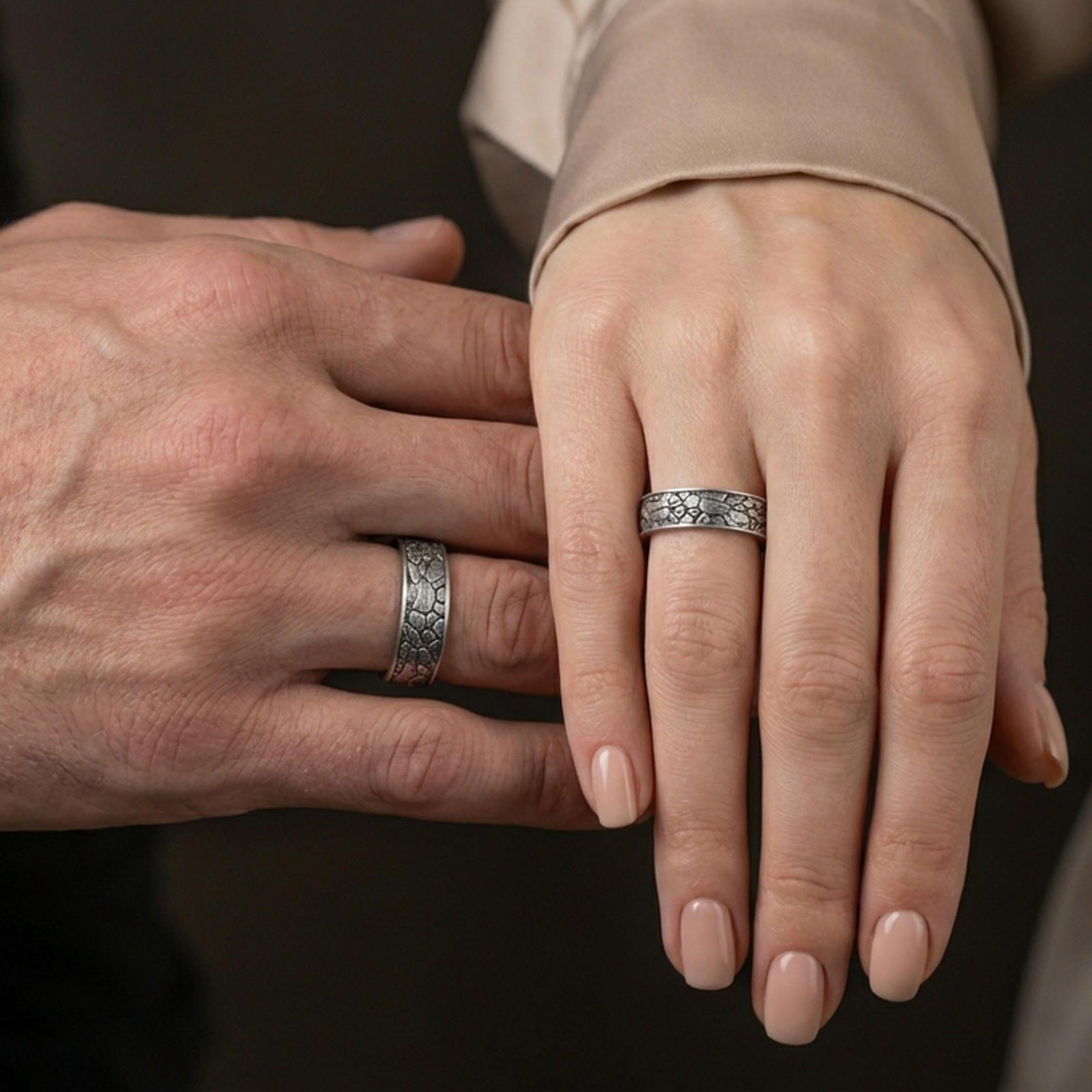 Oxidized sterling silver pebble texture band ring worn on the finger, lifestyle image focusing on rugged minimalist style, matte depth, and everyday wear presence.