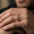 Load image into Gallery viewer, Rose gold plated lizard skin spinner ring worn on the finger, lifestyle image showing elegant rose tone, detailed scale relief, and a premium unisex spinner look.
