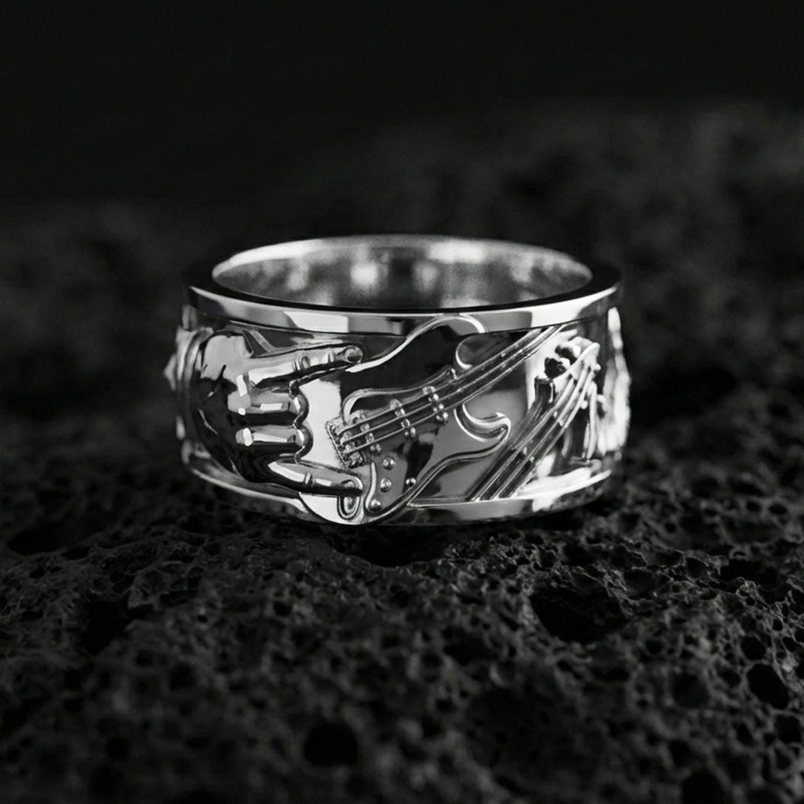 Polished silver guitar ring on volcanic stone, sharp macro shot emphasizing clean reflections, crisp instrument lines, and premium sculpted depth.