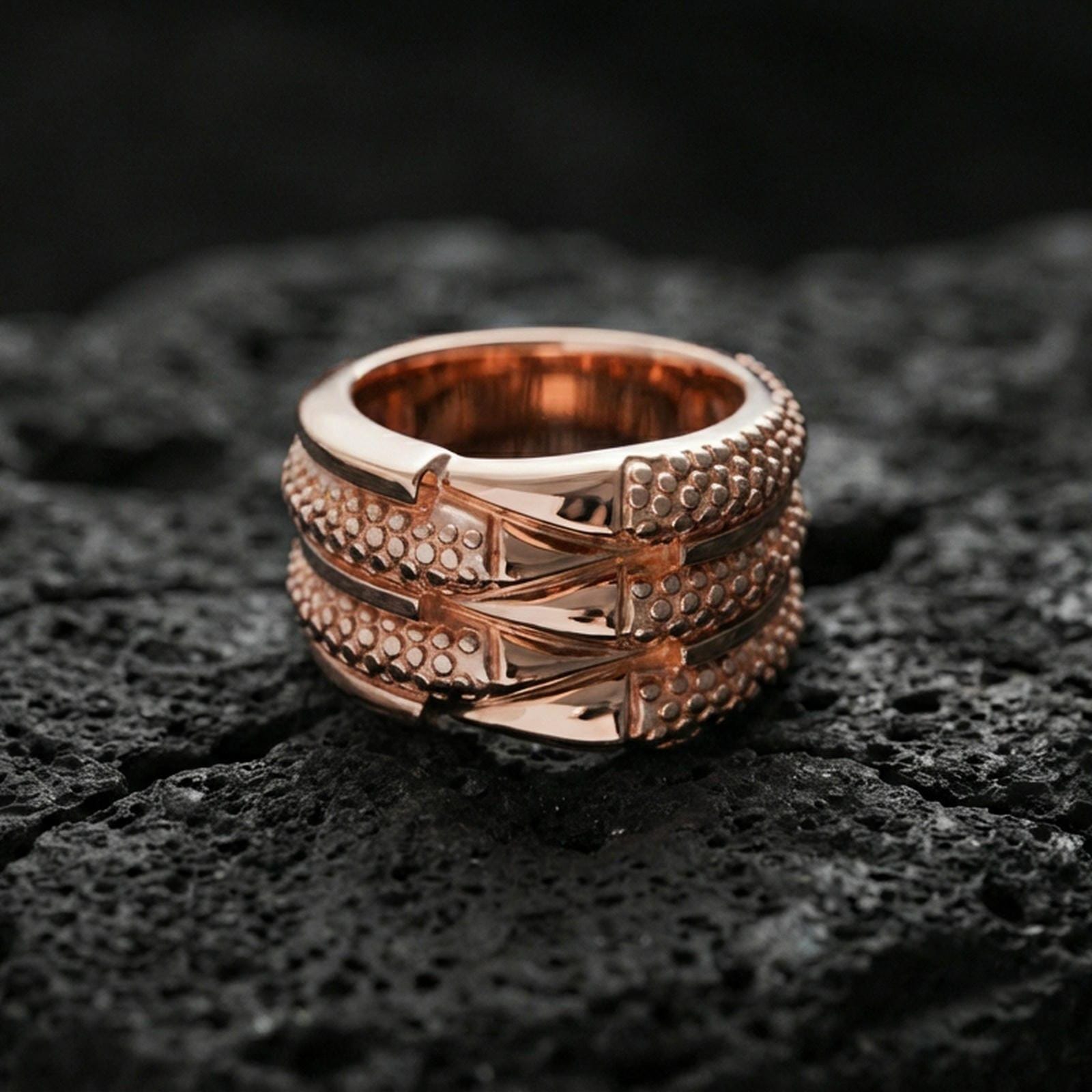 Rose gold plated layered studded band ring on volcanic stone, refined macro close-up capturing soft rose warmth, dimensional layers, and micro-studded texture contrast.