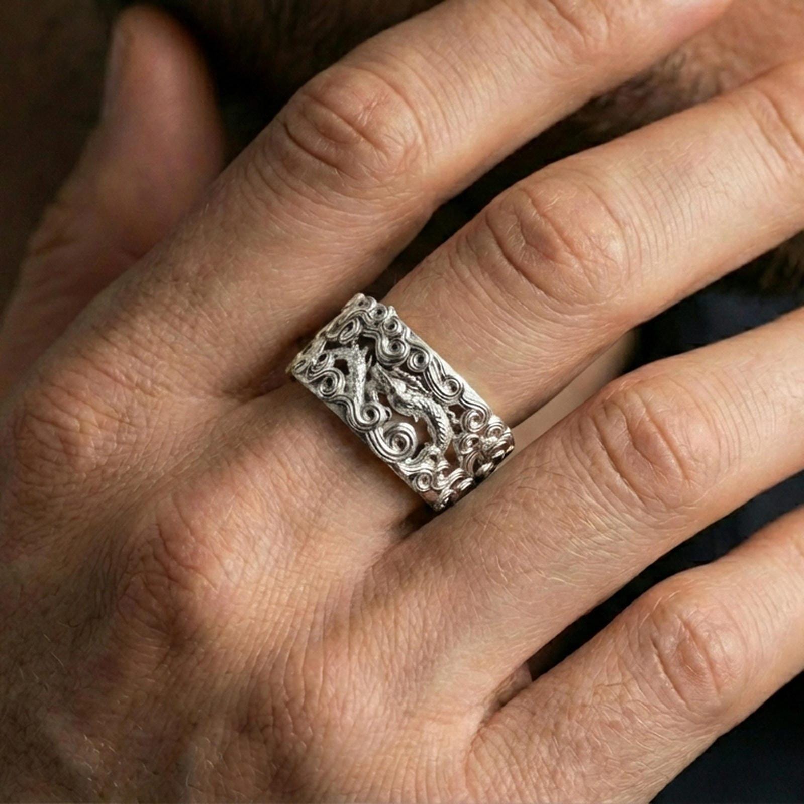 Polished silver dragon cloud band ring worn on the finger, lifestyle shot highlighting clean shine, dimensional scrollwork, and everyday statement styling.