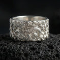 Load image into Gallery viewer, Polished silver dragon cloud band ring on volcanic stone, sharp macro photo emphasizing bright reflections, crisp relief, and layered wave scrollwork.
