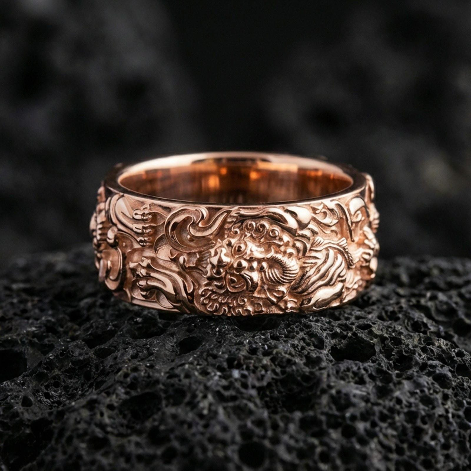 Rose gold plated guardian lion band ring on volcanic stone, refined macro close-up showcasing soft rose warmth, detailed lion expression, and dimensional carved background.