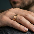 Load image into Gallery viewer, Rose gold plated cross band ring worn on the finger, lifestyle image highlighting elegant rose tone, timeless cross symbolism, and versatile styling.
