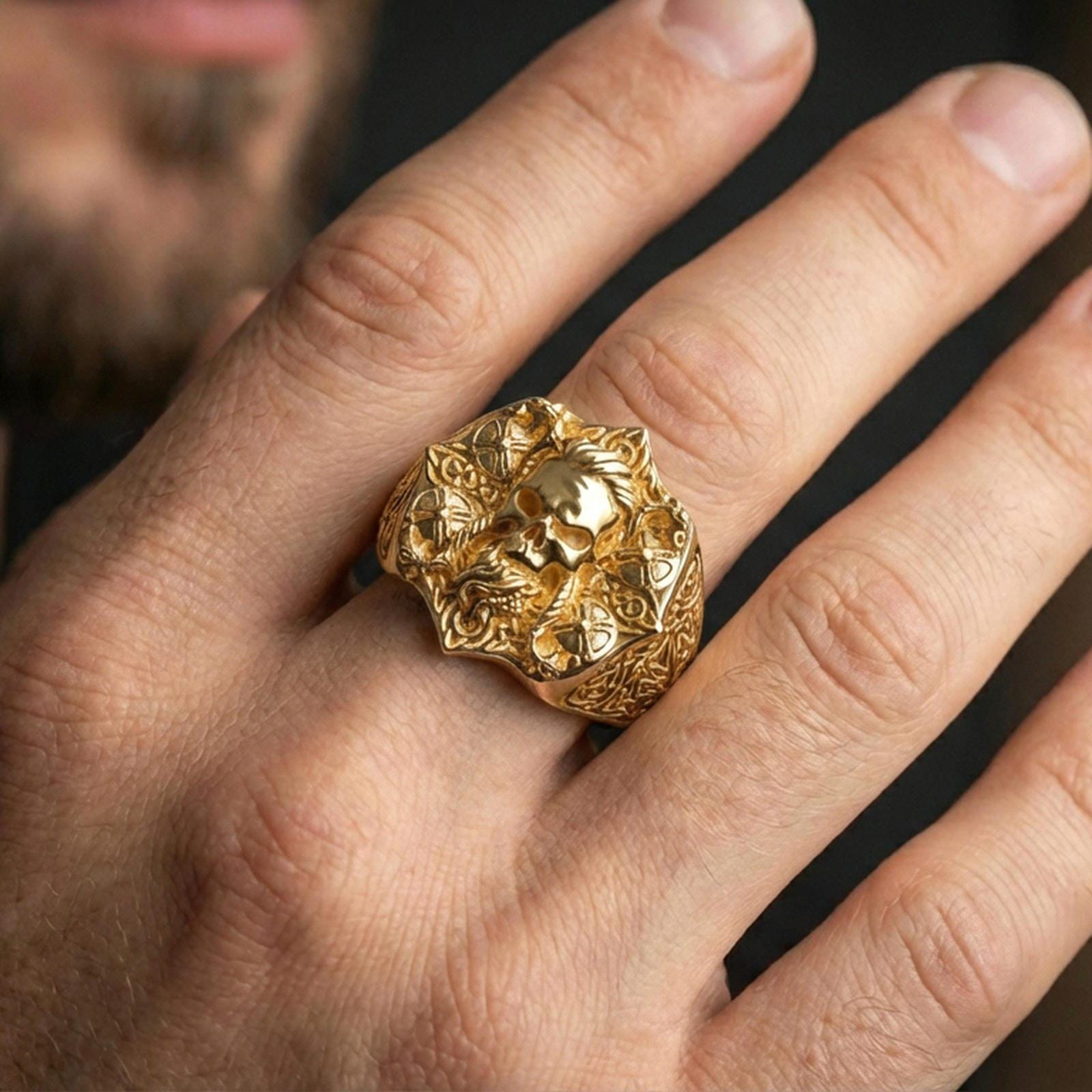 Gold plated skull signet ring on finger, lifestyle image emphasizing the bright finish and intricate Celtic pattern engraving