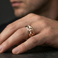 Load image into Gallery viewer, Mechanic style spinning fidget band ring worn on a finger, rose gold plated look with refined warmth and clearly visible faceted geometry.
