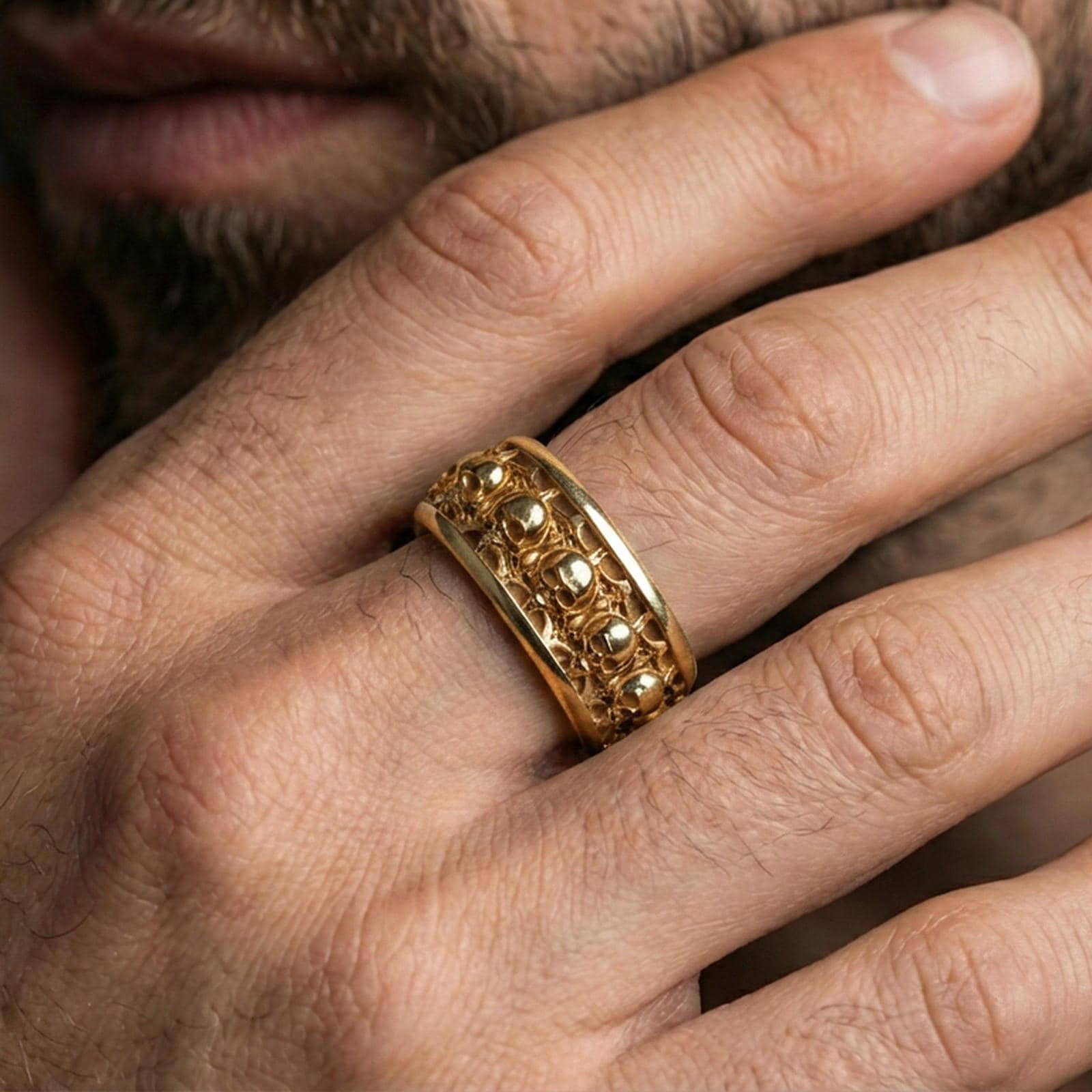 Skull motif sterling silver band ring worn on a finger, gold plated look for a bold statement while keeping the skull texture clearly visible.