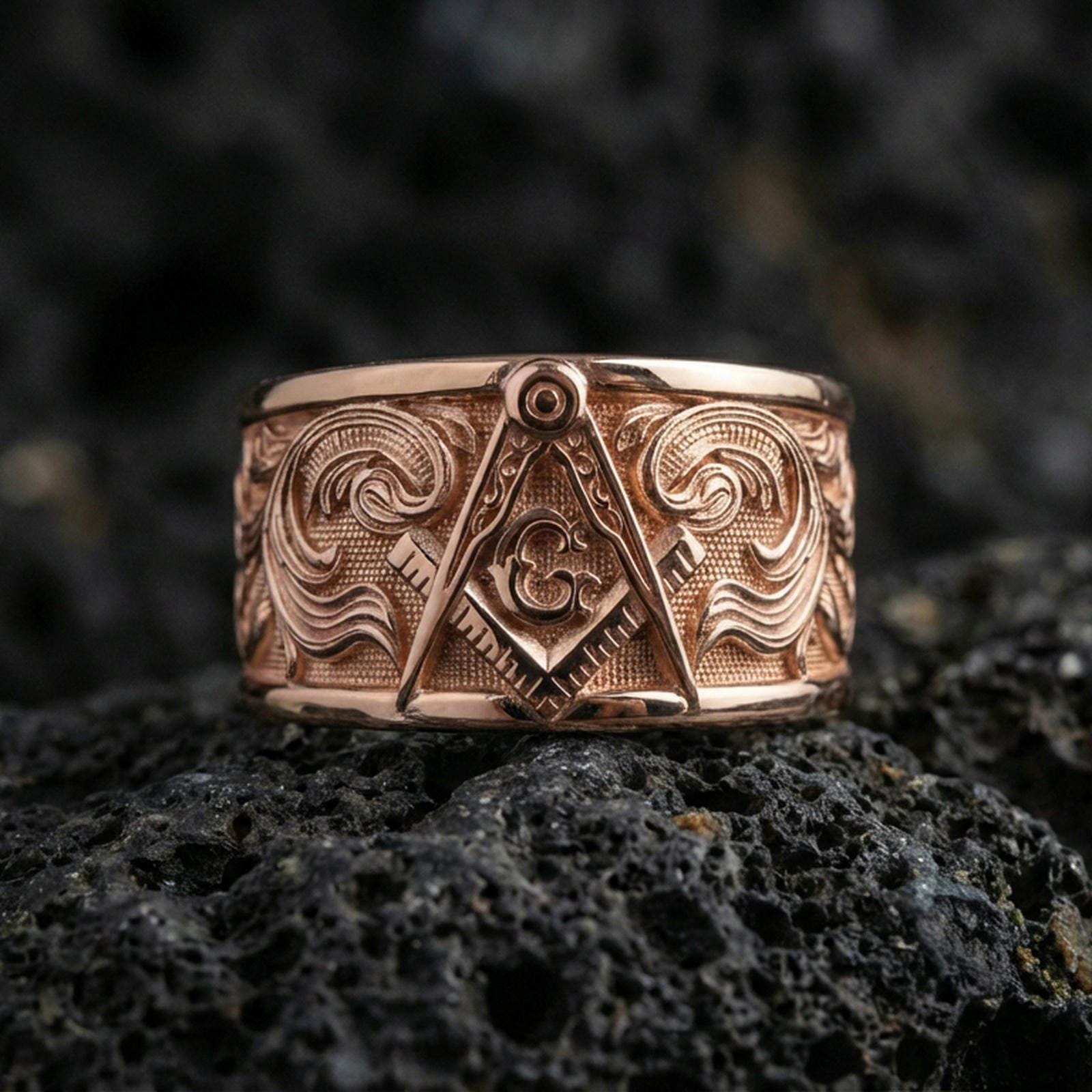 Sterling silver Masonic square and compass band ring on black volcanic stone, presented in a rose gold plated finish with a softer warm tone that enhances the emblem depth and ornamental engraving.