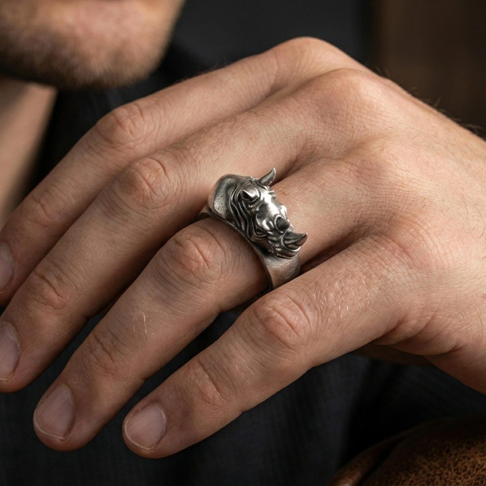 Sterling silver rhino head ring worn on a finger, oxidized finish adding bold contrast to the rhino head relief for a rugged statement look.
