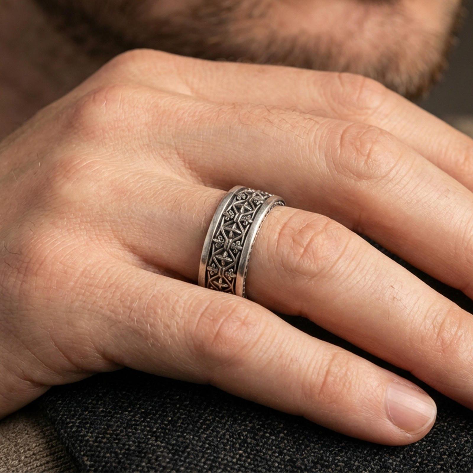 Gothic fleur-de-lis band ring worn on a finger, oxidized sterling silver finish creating strong contrast for the fleur-de-lis and cross details.