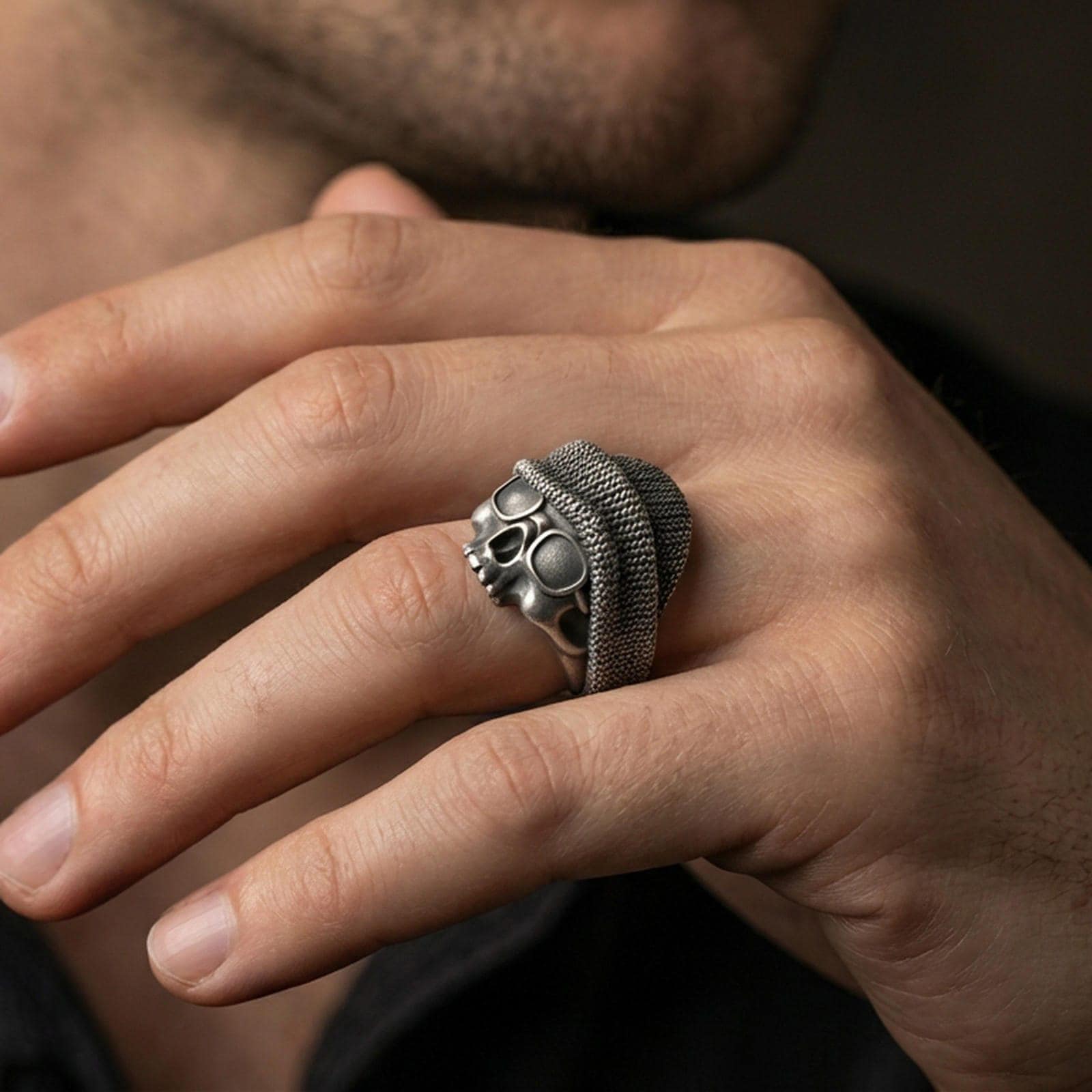 Oxidized skull beanie ring worn on a finger, lifestyle close-up showing gritty biker aesthetic and bold statement look