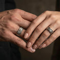 Load image into Gallery viewer, Angel wing sterling silver band ring worn on a finger of a woman and man, oxidized finish creating a bold vintage look and clear feather definition.
