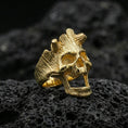 Load image into Gallery viewer, Gold plated openwork skull ring on volcanic rock, premium macro shot emphasizing bold skull silhouette and high-contrast grain texture
