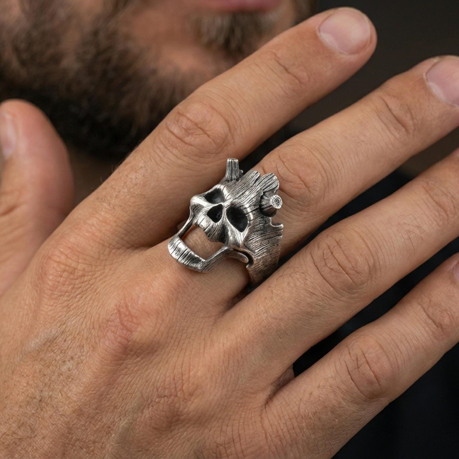 Oxidized openwork skull ring worn on a finger, lifestyle close-up showing gothic statement style and dramatic negative space design