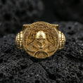 Load image into Gallery viewer, Gold plated Viking helmet and crossed axes ring on volcanic rock, premium macro photo emphasizing high-contrast carvings and bold shield-like face
