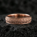 Load image into Gallery viewer, Rose gold plated sterling silver band on volcanic stone, detailed starburst floral engraving, clean minimal high-end close-up.

