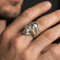 Load image into Gallery viewer, Polished silver skull ring with claw hand worn on the finger, wearable shot highlighting clean shine, sharp skull teeth and sculpted bone fingers
