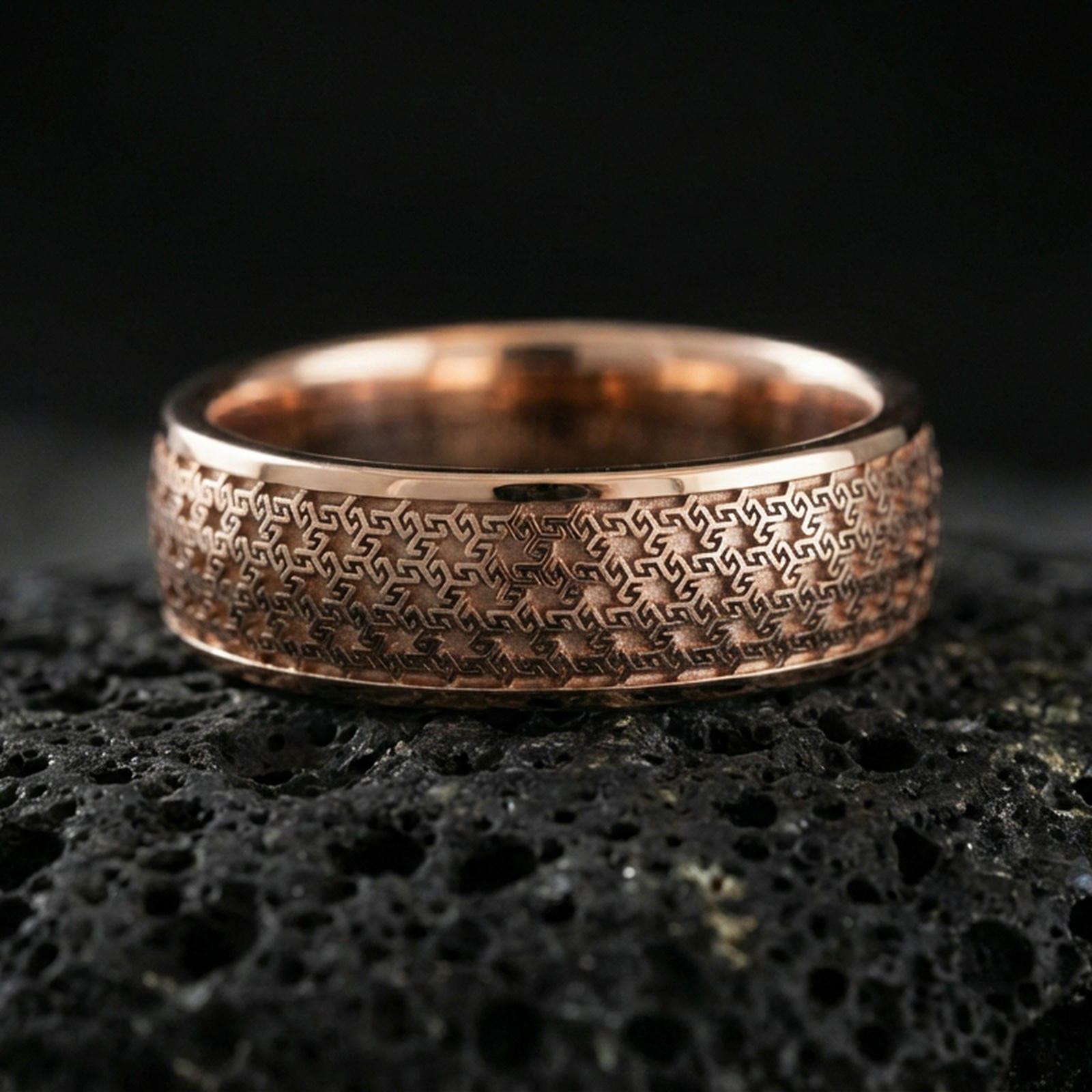 Rose gold plated sterling silver band on volcanic stone, intricate repeating geometric texture, minimal high-end close-up.