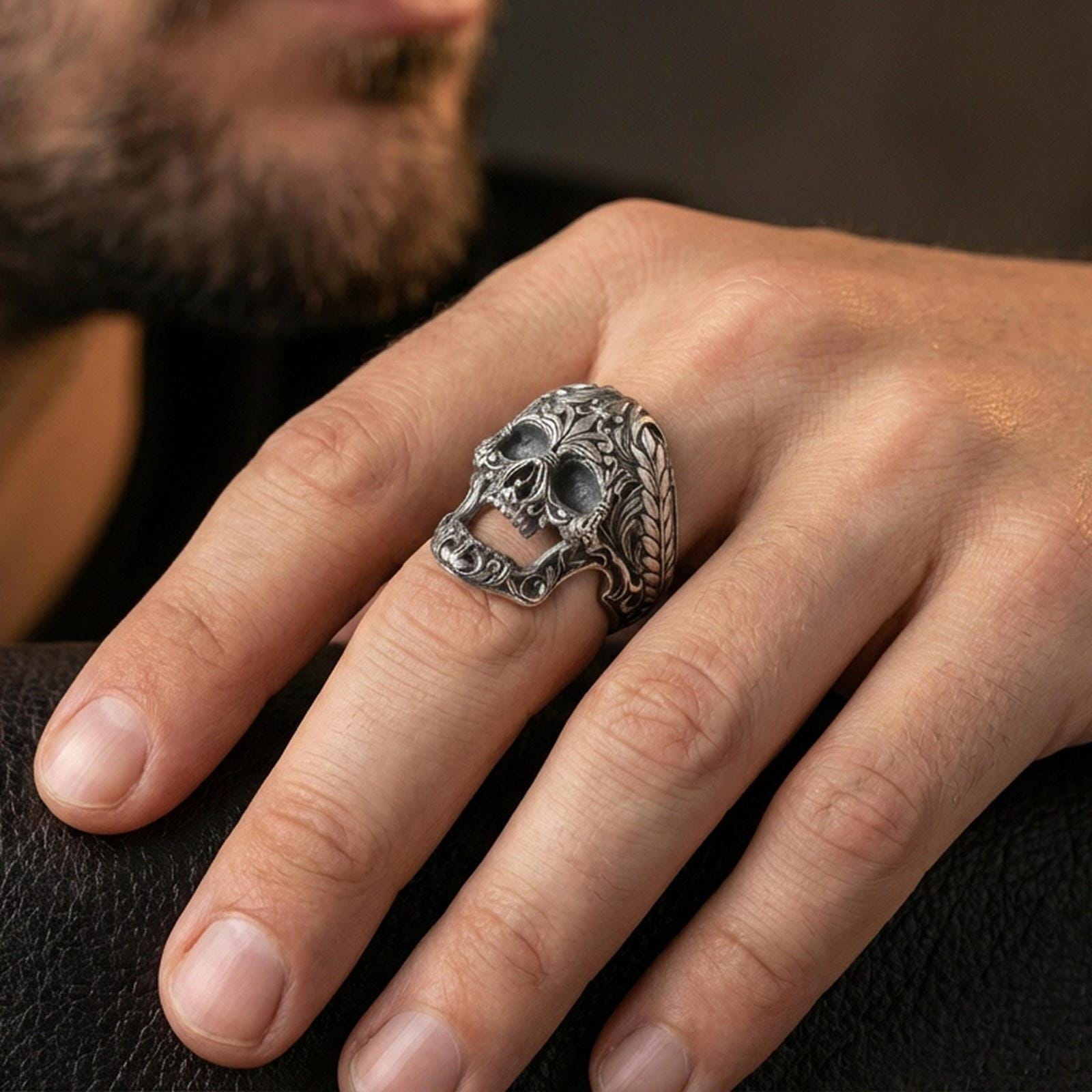 Oxidized filigree skull ring worn on a finger, close-up lifestyle shot showing darkened recesses, ornate baroque carving and bold gothic statement look