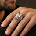 Load image into Gallery viewer, Polished silver ornate skull ring worn on the finger, wearable photo highlighting reflective finish, detailed scrollwork filigree and rope-edge band
