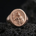 Load image into Gallery viewer, Rose gold plated Greek warrior signet ring featuring a helmeted fighter holding a spear and shield, macro product shot on black volcanic rock
