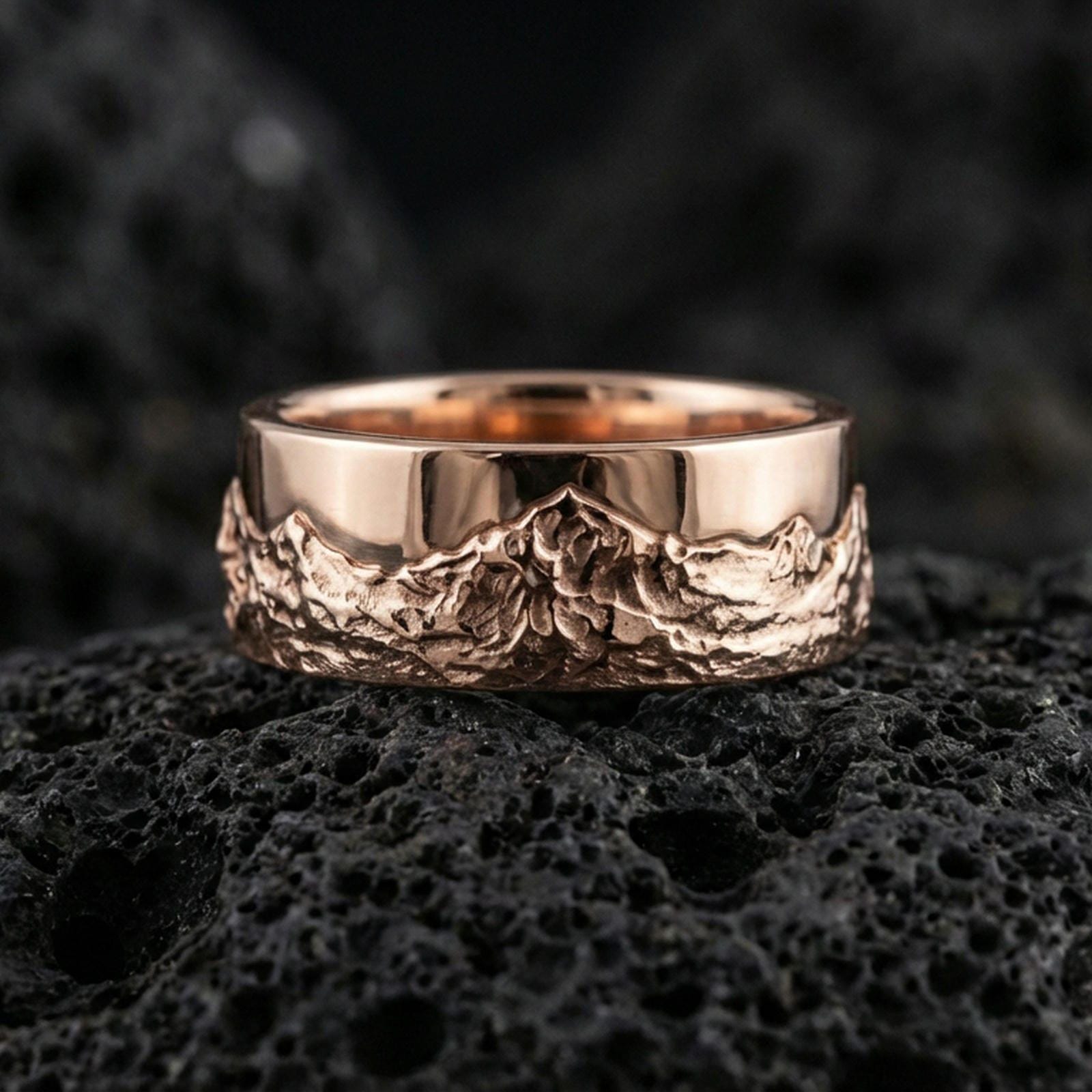 Rose gold plated sterling silver mountain scene ring on volcanic stone, sculpted mountain relief with strong contrast, minimal high-end close-up.