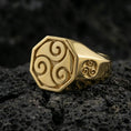 Load image into Gallery viewer, Gold plated octagon signet ring with engraved Celtic triskelion motif and small side triskelion emblem, macro image on black volcanic rock
