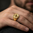 Load image into Gallery viewer, Gold plated compass signet ring worn on a finger, lifestyle image emphasizing the directional letters and star relief details
