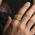 Load image into Gallery viewer, Gold plated fleur-de-lis signet ring worn on a finger, close-up lifestyle image showing the ornate botanical carving
