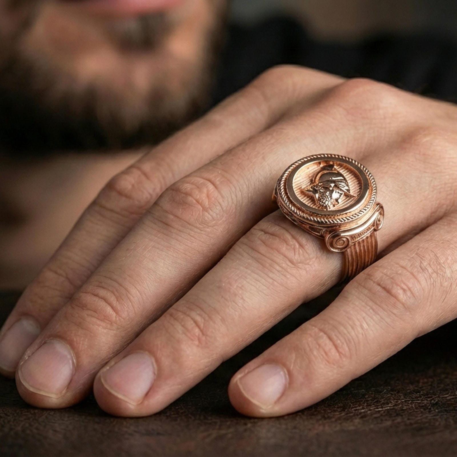 Rose gold plated Greek coin ring on a finger, lifestyle photo focusing on the coin portrait depth and vintage-style details