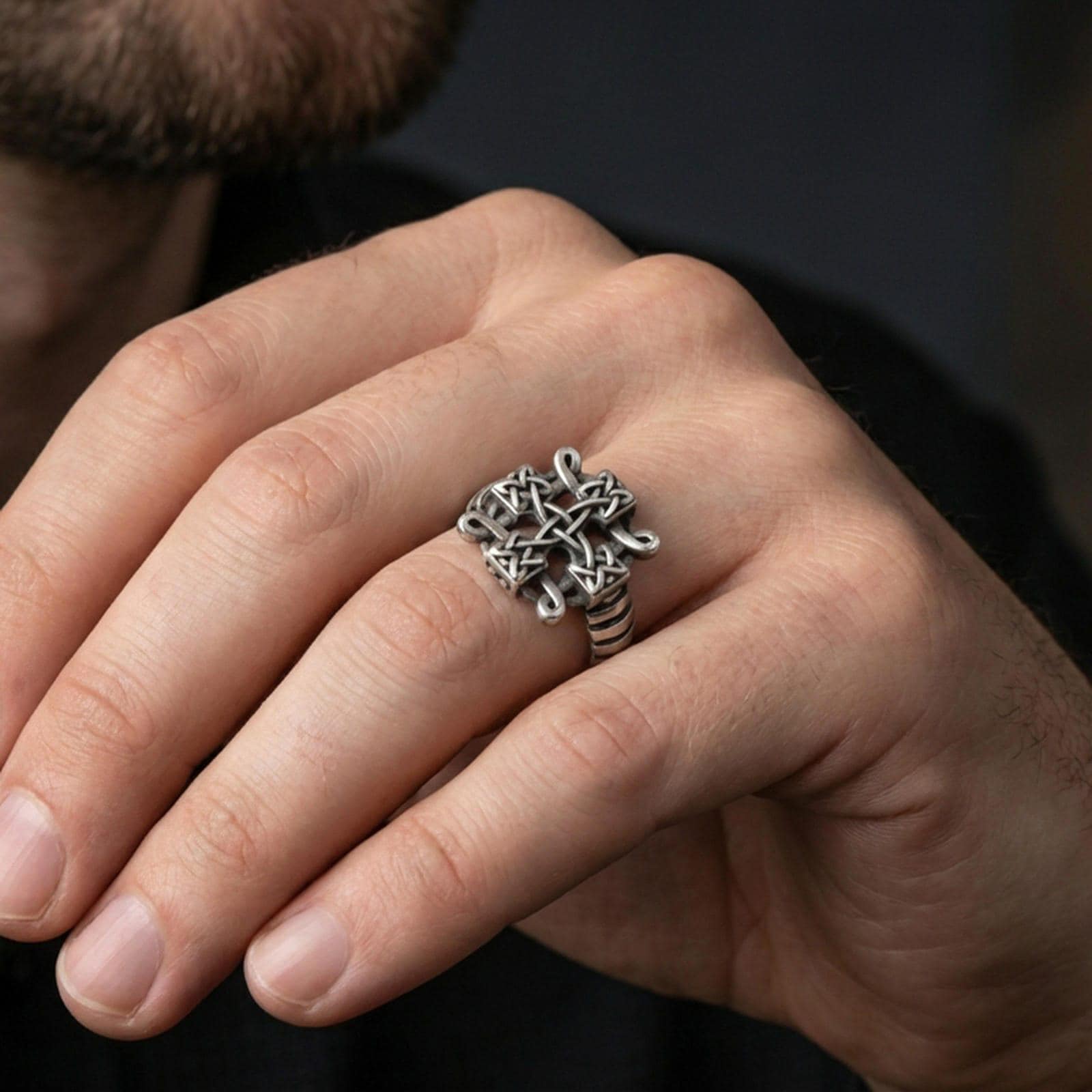Oxidized Celtic knot cross ring worn on a finger, lifestyle close-up highlighting the darkened knot recesses and bold gothic-celtic profile