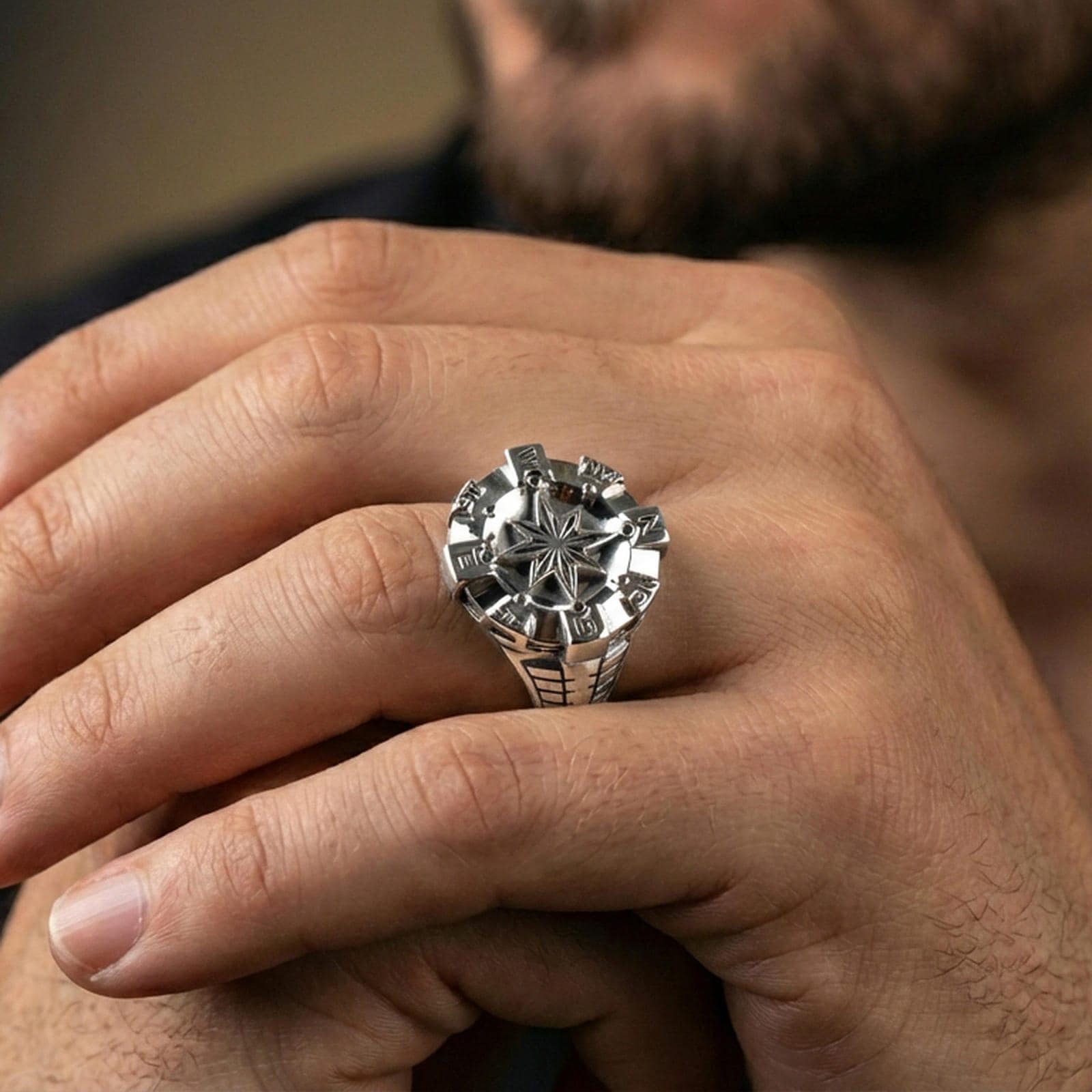 Polished silver compass signet ring on the finger, wearable photo emphasizing the crisp eight-point star and engraved letters