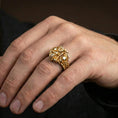 Load image into Gallery viewer, Gold plated double skull motorcycle ring worn on a finger, close-up lifestyle image showcasing the bold skull faces and chain accents
