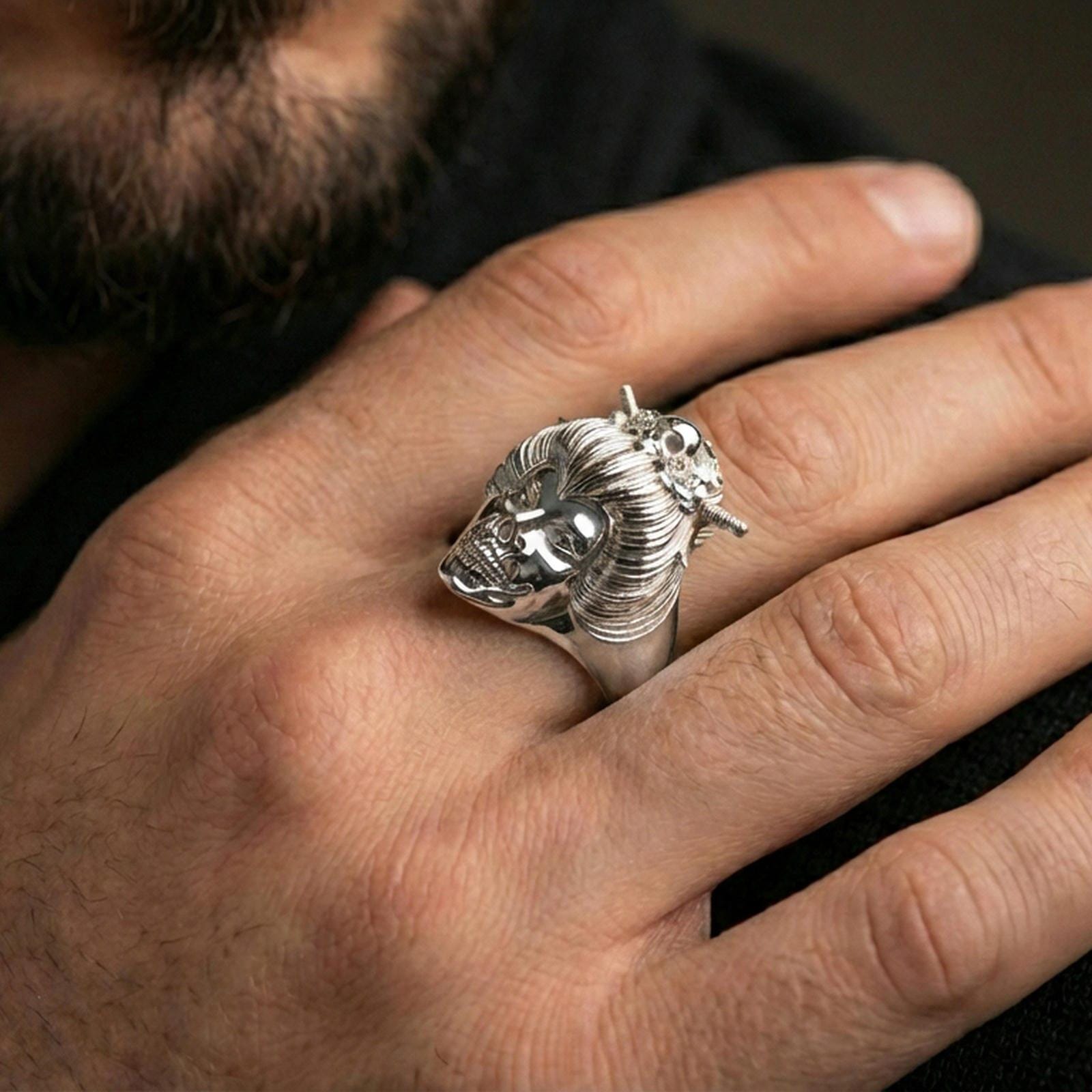 Polished silver geisha skull ring on the finger, wearable photo emphasizing the intricate hair texture and ornamental floral accents
