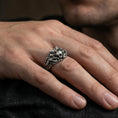 Load image into Gallery viewer, Oxidized skull ring worn on a finger, lifestyle close-up highlighting the crowned spikes and chain-link band details
