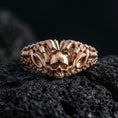 Load image into Gallery viewer, Rose gold plated skull ring with crowned skull centerpiece and detailed chain-link sides, close-up product shot on black volcanic rock
