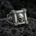 Load image into Gallery viewer, Oxidized sterling silver skull ring with square frame setting and lab diamond accents, macro product photo on black volcanic rock
