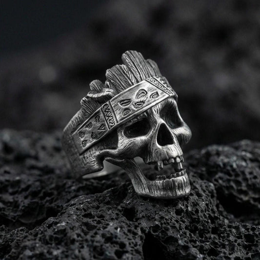 Oxidized sterling silver skull ring with carved woodgrain texture and engraved band details, macro product photo on black volcanic rock