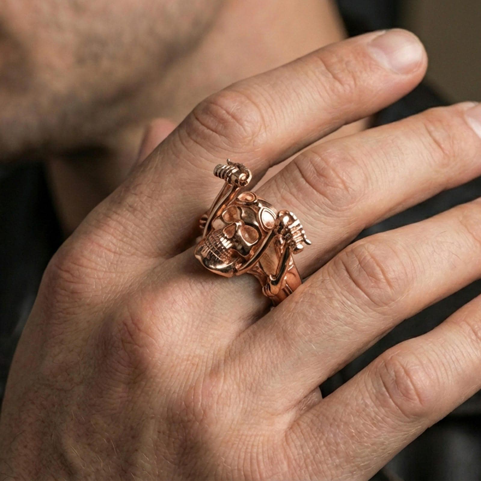 Rose gold plated skull biker ring worn on a finger, lifestyle shot focusing on the aviator goggles and bold skull profile