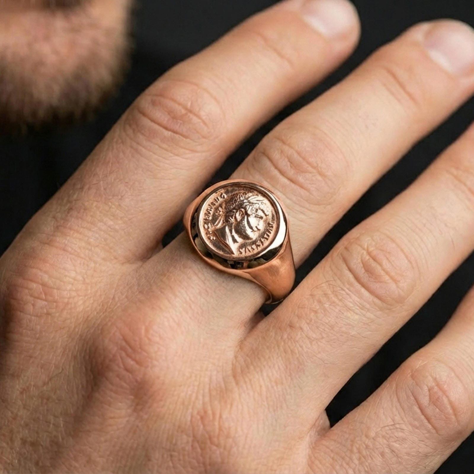 Rose gold plated Roman coin ring worn on a finger, close-up lifestyle image showing the Augustus portrait and antique coin detail