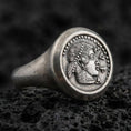 Load image into Gallery viewer, Oxidized sterling silver Greek coin signet ring with a classical female profile and dotted border, macro photo on black volcanic rock
