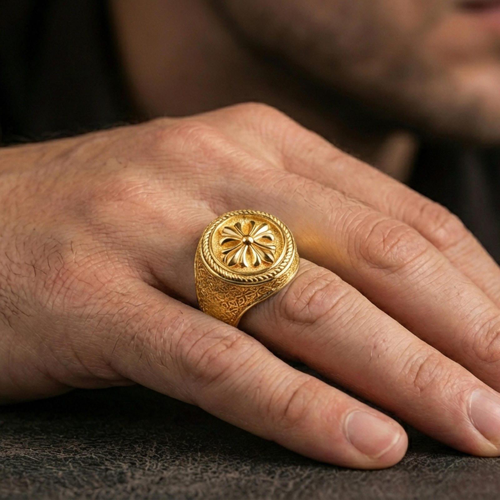 Gold plated six-petal rosette signet ring worn on a finger, lifestyle close-up showing the floral centerpiece and bold profile