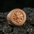 Load image into Gallery viewer, Rose gold plated rosette signet ring with raised flower medallion and rope border detail, close-up on volcanic rock
