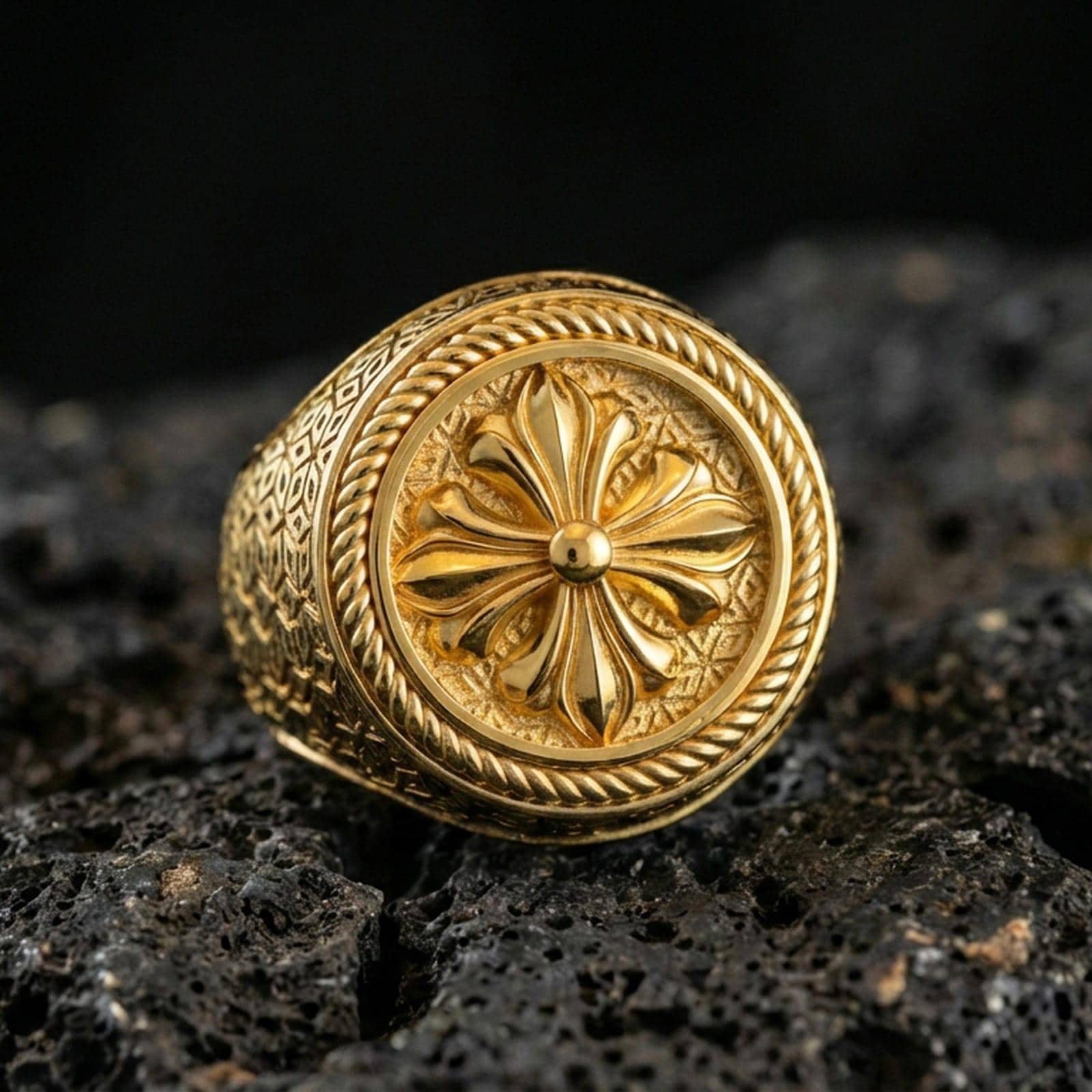 Gold plated floral signet ring with six-petal rosette emblem and rope-edge bezel, macro product photo on black volcanic rock