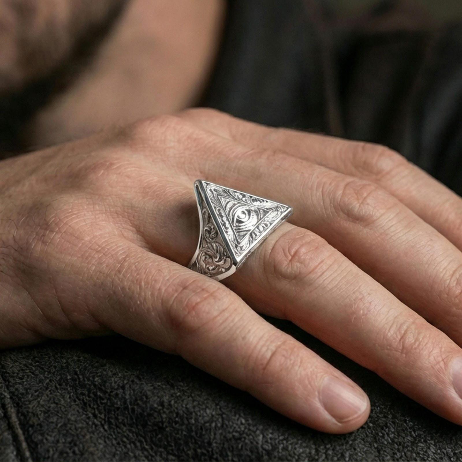 Polished silver all-seeing eye ring on the finger, wearable close-up emphasizing the triangle face and crisp relief details