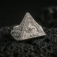 Load image into Gallery viewer, Polished silver pyramid signet ring featuring an engraved all-seeing eye inside a triangle, close-up on volcanic stone
