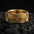 Load image into Gallery viewer, Gold plated ornate engraved band ring on volcanic rock, raised diamond pattern with detailed filigree accents, luxury jewelry product photography.
