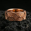 Load image into Gallery viewer, Rose gold plated sterling silver ornament band on volcanic stone, intricate engraved diamond panels with deep contrast and clean edges, minimal high-end close-up.
